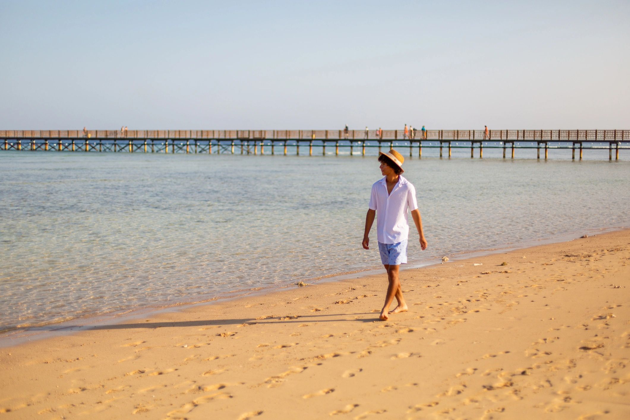Traveler walking along a quiet sandy shoreline